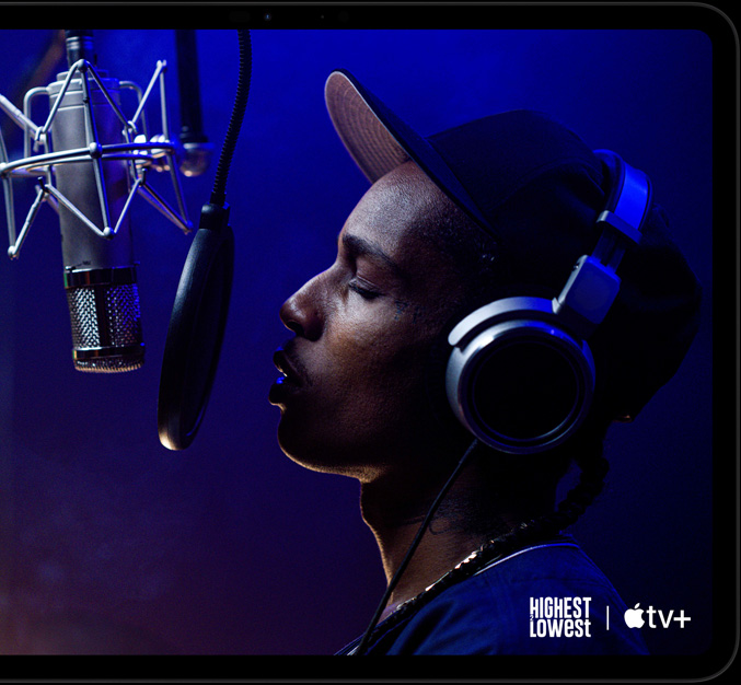 iPad Pro, horisontaalpaigutus, esikülg, kosmosemust värv, ümarad nurgad, must ekraani serv, ekraanil mängimas AppleTV+ stseen Apple TV+ originaalfilmist Highest 2 Lowest, kus ASAP Rocky rollis Yung Felon räpib mikrofoni